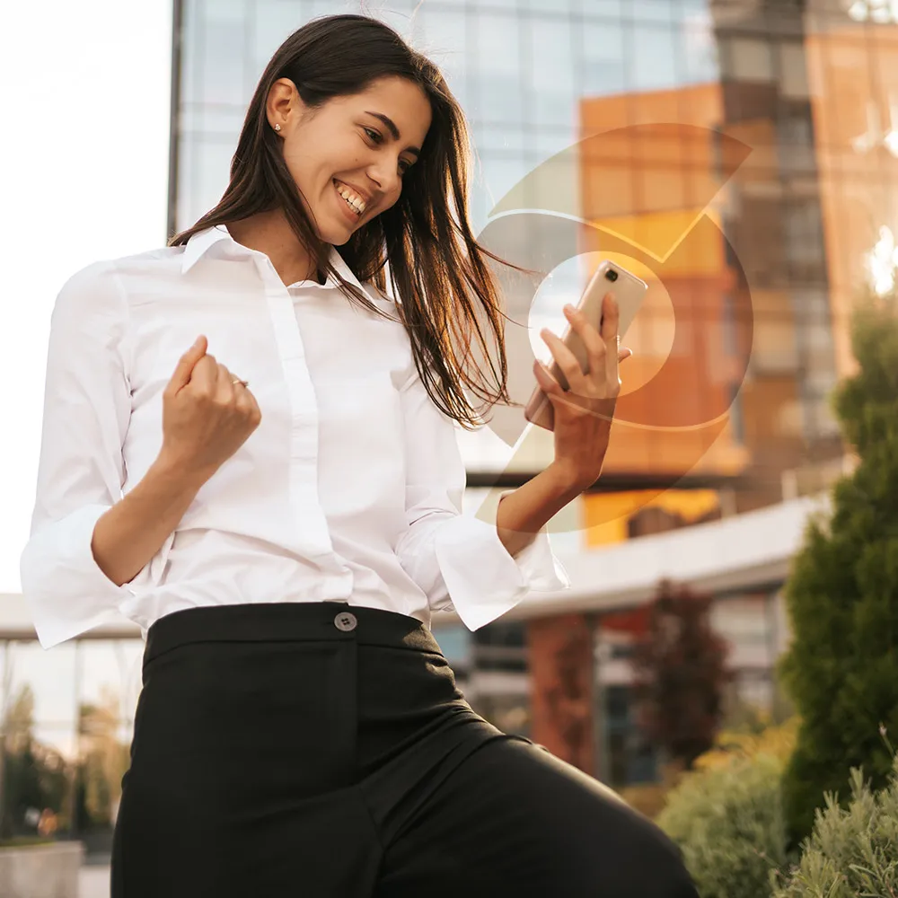 Corretora comemorando com o celular na mão
